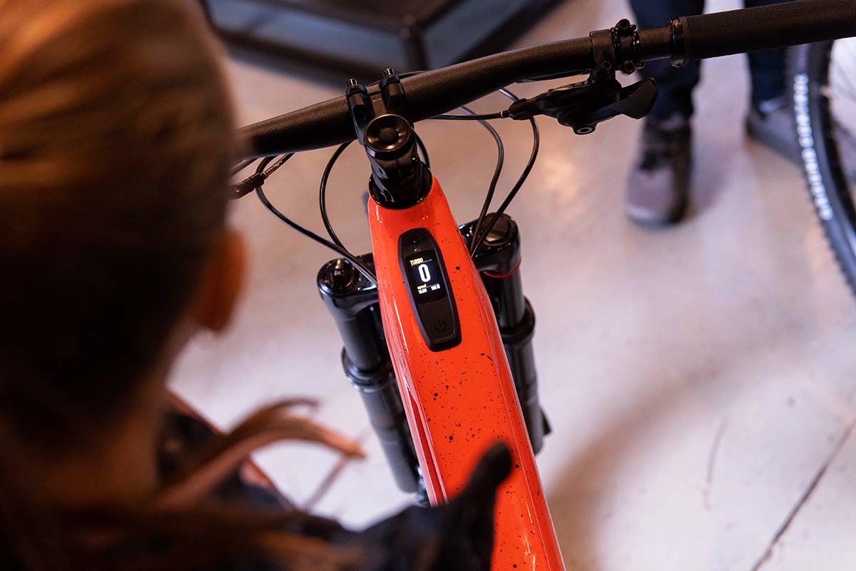 Mecánico revisando una bicicleta Specialized naranja en el taller del lodge
